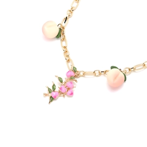 Collier chaîne dorée avec trois pendentifs pêche rose et blanc aux détails de feuilles vertes