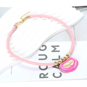 Macro detail of pink PU leather choker with golden leaf enamel pendant on white background