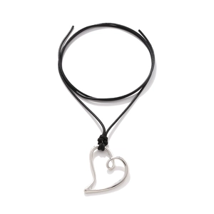 Exaggerated silver heart pendant necklace with black cord on white background
