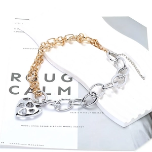 Détail de la chaîne en métal mixte avec pendentif cœur évidé et fermoir ajustable