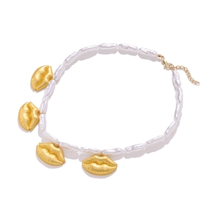Collier de perles baroques avec pendentifs lèvres dorés uniques sur fond blanc épuré
