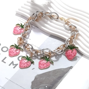 Detail of strawberry charm necklace with pink enamel and mixed gold-silver chain links