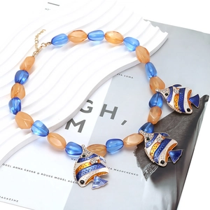 Detail of colorful resin tropical fish pendants on a summer style beaded ocean necklace