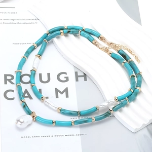 Double-layered beaded necklace with green resin tubes, pearls, and gold-tone accents