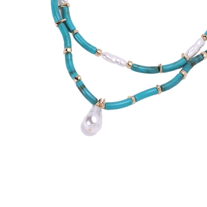 Close-up of bohemian double-layer necklace with turquoise resin beads and baroque pearls