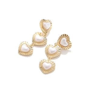 Detailed view of vintage gold heart earrings with tiered baroque pearls and pleated edges