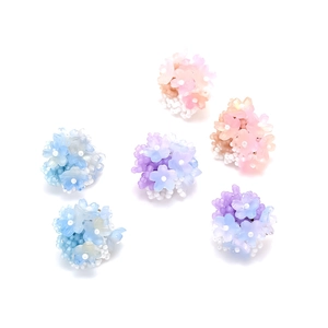 Macro view of six-piece handmade beaded flower studs in pastel gradient resin colors