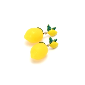 Macro detail of yellow lemon drop earrings with sparkling green rhinestone leaves