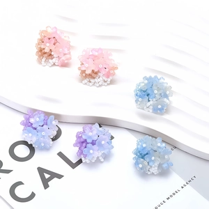 Handmade woven flower stud earrings set in pastel pink, purple, and blue resin beads