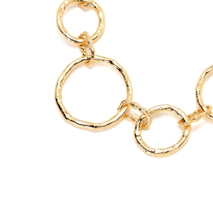 Macro shot of gold hammered textured metal rings linked on a vintage necklace