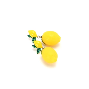 Detail of yellow lemon earrings with green leaves and small turquoise rhinestones