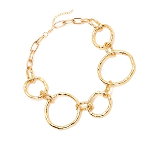 Detail of irregular golden metal link necklace with textured hammered finish rings