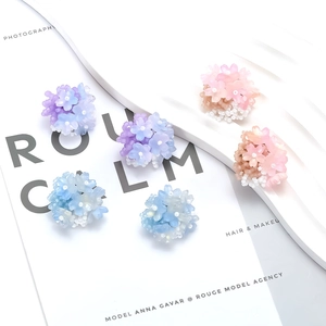 Detailed view of handmade beaded flower earrings in purple, pink and blue colors