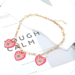Goldkette mit rosa Emaille-Herzanhängern und funkelnden Stern-Strasssteinen verziert