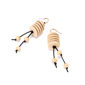Detailed macro view of bohemian tiered wood disc earrings with black rope tassels