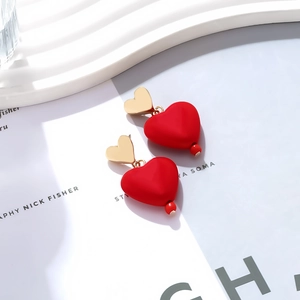 Detail of red matte heart earrings with golden heart studs and bead accents