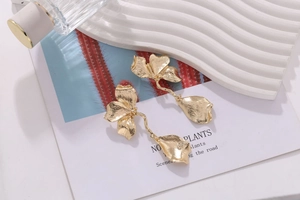 Detail of vintage gold flower drop earrings with brushed metal petals on display tray