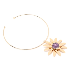 Macro detail of gold flower pendant with purple glass center on minimalist metal collar