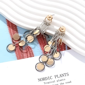 Detail shot of multi-layered metallic gold, silver, and black tiered fringe drop earrings
