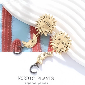 Detail of vintage gold sun and moon face earrings with black accents on a stylish background