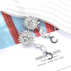 Vintage silver sun and moon drop earrings with rhinestones on a minimalist white card
