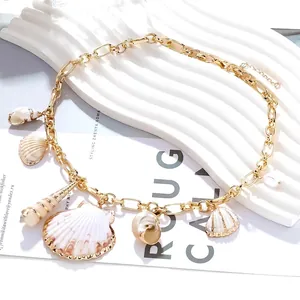 Collier à grosse chaîne dorée orné de six pendentifs en coquillages naturels bordés d'or