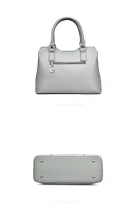 Détails du sac en cuir gris montrant la poche arrière zippée et les pieds en métal
