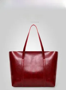 Vue de face d'un grand sac cabas rouge foncé avec texture cuir brillant et fines anses