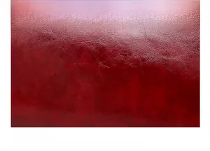 Détail du cuir ciré rouge vin lisse avec une texture souple et une finition brillante