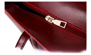 Détails de la fermeture éclair dorée et coutures sur un sac à main rouge brillant