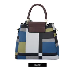 Back view of a geometric color-block handbag with gray fur pompom and dark brown handle