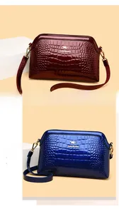 Detail of crocodile pattern patent leather shoulder bags in wine red and royal blue colors