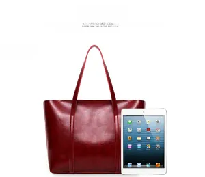 Grand sac cabas bordeaux en cuir ciré présenté avec un iPad pour comparer la taille