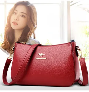 Detail of dark red lychee texture leather with golden kangaroo logo and metal brand lettering