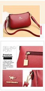 Detail view of red lychee grain leather crossbody bag with golden kangaroo logo hardware
