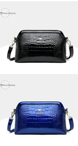 Detail view of glossy crocodile pattern shoulder bags in black and blue with gold kangaroo logo