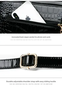 Detail of black patent faux leather bag with crocodile texture and metal strap buckle