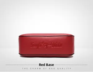 Detail view of red soft leather crossbody bag bottom with textured litchi pattern