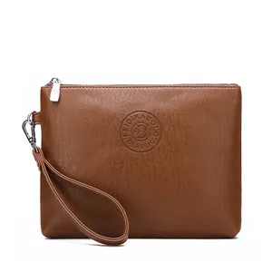 Detailed macro of brown litchi grain leather clutch bag with silver metal zipper