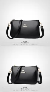 Detail of black pebbled leather crossbody bag with gold kangaroo logo and hardware