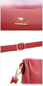Detail view of red lychee grain leather handbag with gold-tone buckle and logo