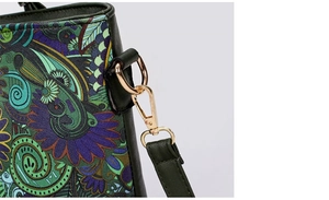 Detail of crossbody bag featuring ethnic forest print and green faux leather with gold clasp