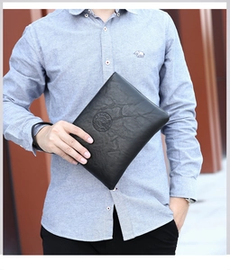 Close-up of black lychee grain leather texture and embossed logo on men's clutch bag
