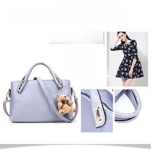 Detail of snake skin texture and gold metal accents on blue faux leather handbag