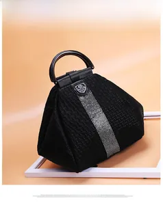 Detail view of black woven texture handbag with silver rhinestone stripes and metal handle