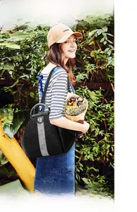 Outdoor lifestyle view of a chic black embossed handbag with sparkling silver diamond strap