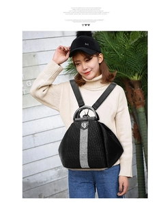 Detail of black woven leather backpack with silver rhinestone trim and metal top handle