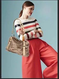 Détail d'un sac bandoulière en fausse fourrure marron avec sangle en cuir à rivets