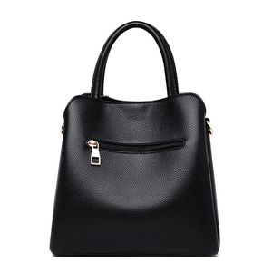 Classic black leather handbag with lychee texture and gold hardware on white background