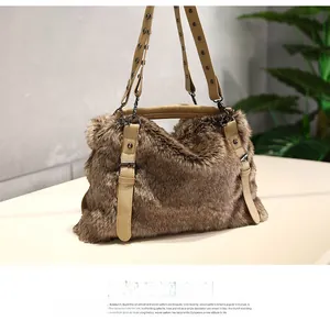 Détail d'un sac à main en fausse fourrure marron avec brides en similicuir et rivets en métal